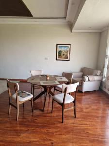 a living room with a table and chairs and a couch at The Polo Residence, Lahore, Near Allama Iqbal International Airport (Apartment) in Lahore