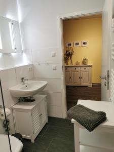 a white bathroom with a sink and a toilet at Moorhexe 2 in Gelbensande