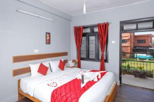 乔奥诺奥尔Hotel Vivek的一间卧室，有一张带红色枕头的床和一扇窗户