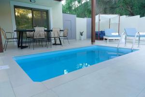 a swimming pool in a patio with a table and chairs at Elite Luxury Villas in Parga