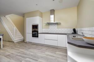 eine Küche mit weißen Schränken und einer Treppe in der Unterkunft Westraat 114 in Blankenberge