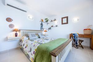 Habitación blanca con cama y escritorio en Serenidade - sunny flat in the centre of Salema, en Salema