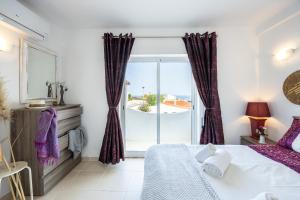 1 dormitorio con cama y ventana grande en Serenidade - sunny flat in the centre of Salema, en Salema