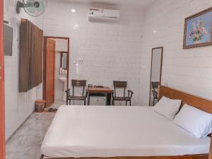 una camera con letto, tavolo e sedie di Khách sạn Ngọc Bích a Phan Rang-Tháp Chàm