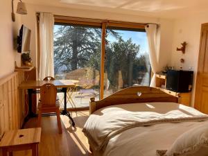 a bedroom with a bed and a desk and a window at Chambre Belledonne in La Tronche