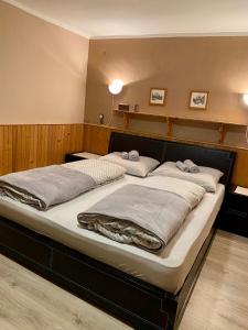 een groot bed in een kamer met twee kussens erop bij Privát Vavrúš in Donovaly
