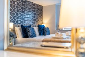 a bedroom with a bed with blue and white pillows at Charming Apartment In Andover Town Centre 55'' 4K Smart TV Netflix in Andover