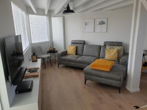 a living room with a couch and a tv at Duinengolf 5 in Middelkerke