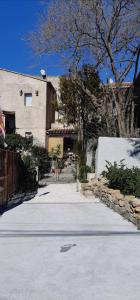 eine Straße mit einem Haus, einem Baum und einem Gebäude in der Unterkunft BANDOL Maison de Campagne in Bandol