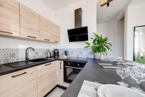 une cuisine avec des placards en bois et un comptoir noir dans l'établissement Le Balcon Annécien 4 - rooftop view for 2-4 people, à Annecy