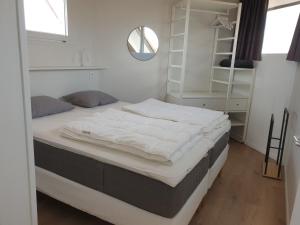 a large bed in a room with a mirror at Duinengolf 5 in Middelkerke