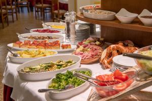 una mesa con muchos platos de comida. en Hotel Europa, en San Martino di Castrozza