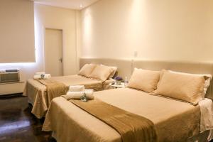 a room with two beds in a room at Novo Hotel Iguaçu in Pôrto União