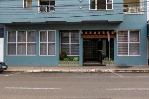 a blue building on the side of a street at Novo Hotel Iguaçu in Pôrto União