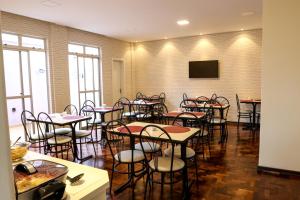 a room with tables and chairs and a flat screen tv at Novo Hotel Iguaçu in Pôrto União