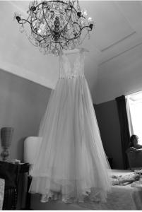 a dress hanging from a chandelier in a bedroom at Suites Edivino Design Capri in Capri