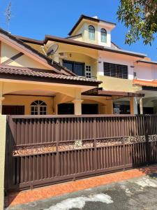 a house with a wooden fence in front of it at To' Teh Homestay in Ipoh