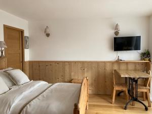 a bedroom with a bed and a desk and a tv at Chambre Belledonne in La Tronche