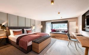 a bedroom with a bed and a desk and a couch at eva,VILLAGE in Saalbach-Hinterglemm