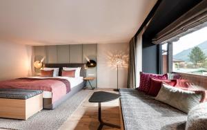 una camera d'albergo con letto e divano di eva,VILLAGE a Saalbach Hinterglemm