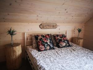 a bedroom with a bed with two pillows on it at Domki Między Drzewami in Bartoszylas