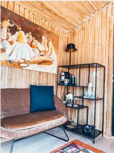 a living room with a couch and a painting on the wall at Joly Tiny House in Overijse