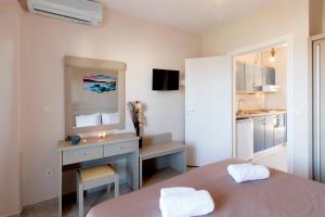 a room with a bed and a desk and a kitchen at Sueño beach hotel in Polychrono