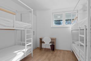 um quarto com beliches, uma secretária e uma cadeira em Hostel Elli em Split