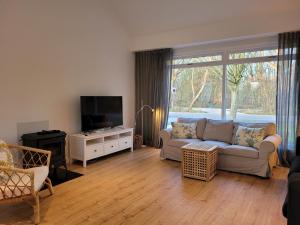 a living room with a couch and a tv at De Egel in Oostkapelle
