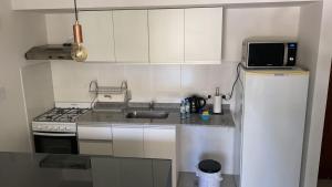 una pequeña cocina con fregadero y microondas en Talavera 480 en Salta