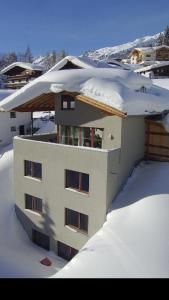 een met sneeuw bedekt gebouw met sneeuw erop bij Chalet Lenzi in Sankt Anton am Arlberg