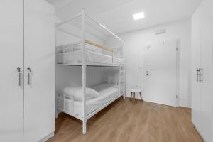 Pokój z białymi łóżkami piętrowymi i drewnianą podłogą w obiekcie Hostel Elli w Splicie