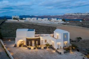 una vista aérea de una casa blanca con playa en Alafropetra Luxury Suites, en Akrotiri