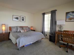 a bedroom with a bed and a desk and a window at MESQUITE ZEN RETREAT in Palm Springs
