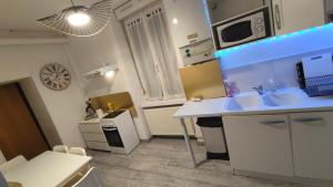 a small kitchen with two sinks and a microwave at Cocooning Logement entier [Parking Gratuit] in Algrange