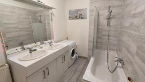 uma casa de banho com 2 lavatórios, um chuveiro e uma máquina de lavar roupa em Cocooning Logement entier [Parking Gratuit] em Algrange