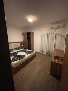 um quarto com 2 camas e piso em madeira em Bashi's Apartments em Donji Štoj