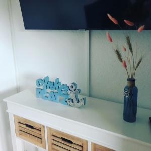 a white shelf with a vase of flowers and a blue vase at Hostel Hof Kranichstein in Kluis