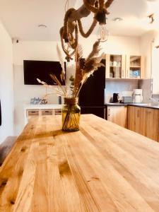 un jarrón con flores sobre una mesa de madera en Hostel Hof Kranichstein, en Kluis