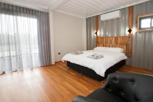 a bedroom with a bed and a couch and a window at Stirling Estate Chalets in Capel