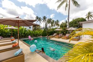 a pool at a resort with people playing in it at Maya Resort Samui - Family resort-Sha Plus Extra in Bophut