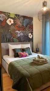 1 dormitorio con 1 cama grande y pared de flores en Le Garden Studio avec terrasse et parking centre ville, en Rouen
