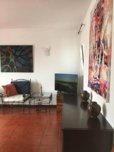 - un salon avec une télévision et un canapé dans l'établissement Green Elephant Place, à Carvoeiro