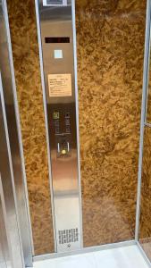Una máquina en el baño con una pared marrón en Village Croisette, en Cannes