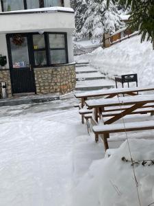 a group of benches covered in snow in front of a building at Montana Residence in Poiana Brasov