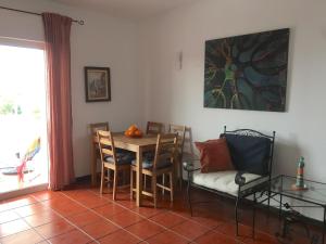 - une salle à manger avec une table, des chaises et un canapé dans l'établissement Green Elephant Place, à Carvoeiro