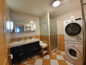 a bathroom with a sink and a washing machine at 3 Allée de l'Orée du Lac in Biarritz