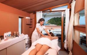 Una mujer está cortando el cabello de una mujer en un salón en Giovanna Regina Hotel, en Gabicce Mare