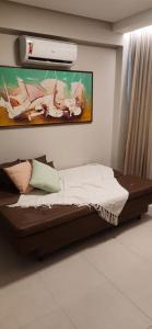 a bed in a room with a painting on the wall at Flat praia dos carneiros eco resort 26 in Tamandaré +32 photos