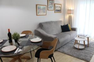 a living room with a gray couch and a table at BEACH FOREST PARADISE in Cabopino